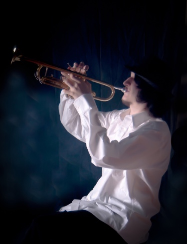 graduating high school boy posing for senior pictures with trumpet