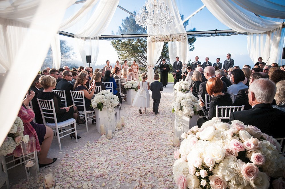 Ring bearer in decorated rose petal aisle wedding tent