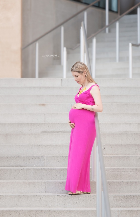 maternity photo of pregnant woman in pink dress at steps of the Mint Museum in Uptown Charlotte, NC
