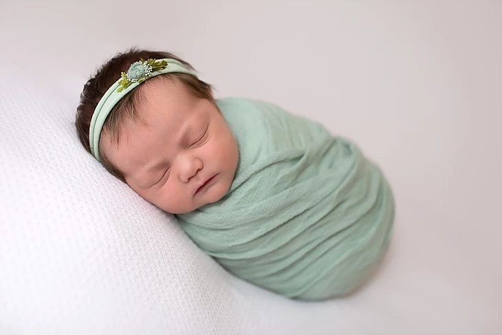 Gorgeous traditional newborn portrait with baby wrapped in a blanket with a hand made headband by Alyssa Renee Photography in Jacksonville Florida