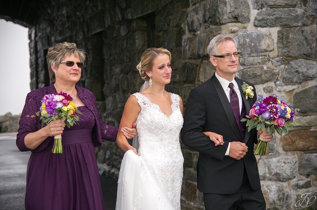 bride walking down the aisle with both parents