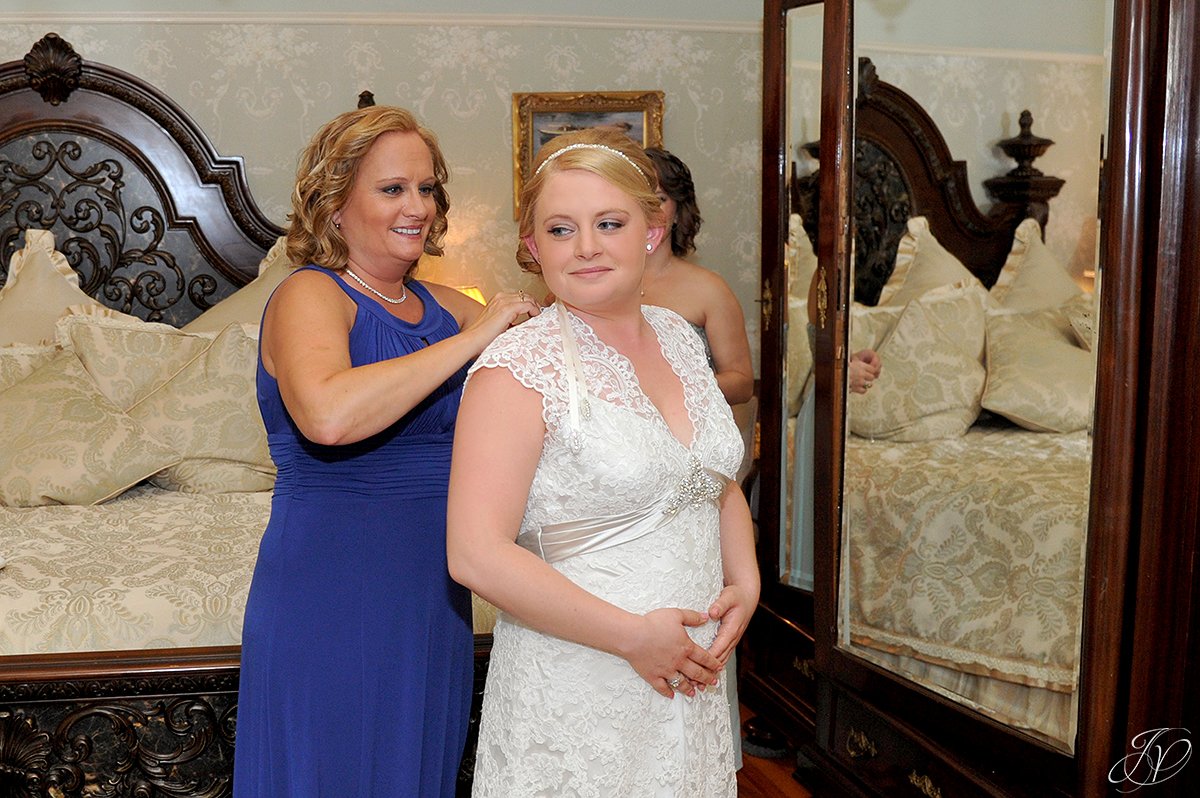 bride getting wedding prep help from mother