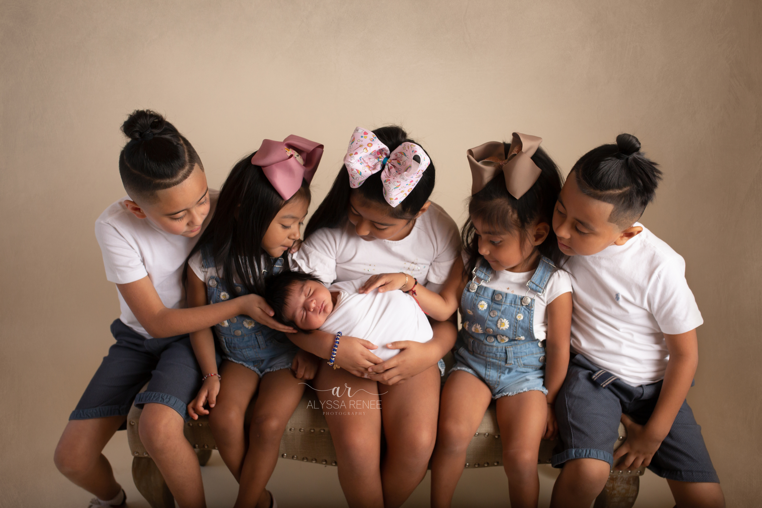 photo of siblings all looking at baby in this portrait by alyssa renee photography