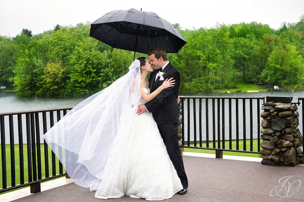 bride and groom in the rain photo, bride and groom with umbrella photos, portraits of beautiful bride and groom kissing, kissing bride and groom photo