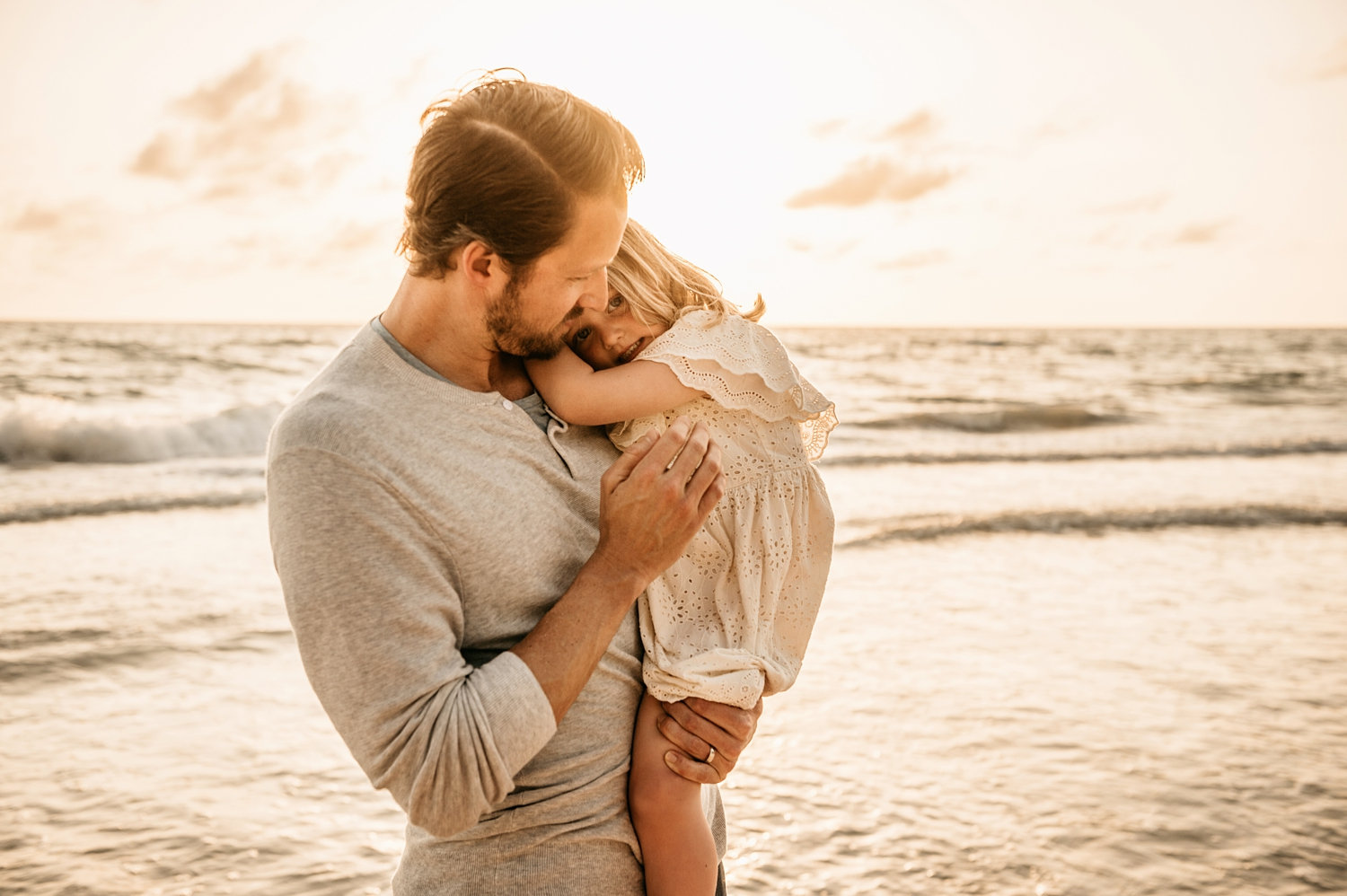father holding young daughter in his arms, Naples Beach, Florida, Rya Duncklee