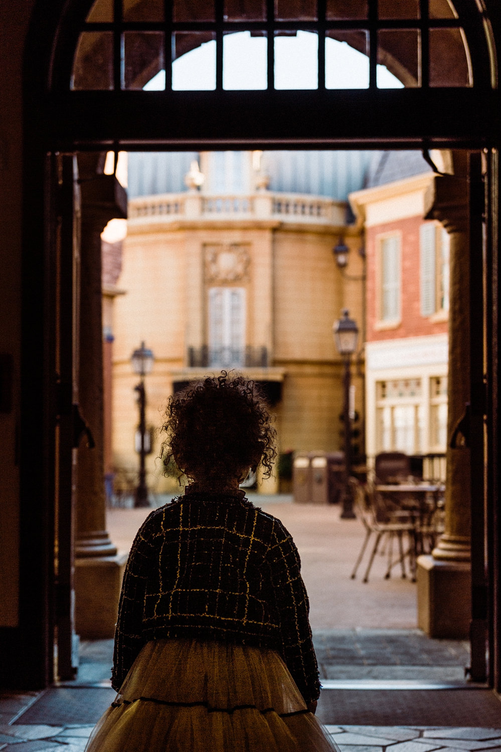 curly haired little girl standing in a tunnel, EPCOT, French pavilion