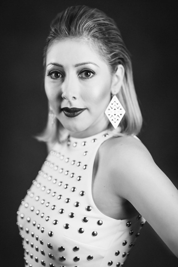Black and White professional female headshot with studded white dress and studio lighting. Professional headshots and team portraits in studio with Adam Trujillo.