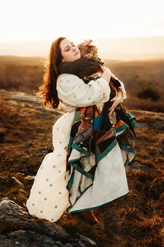 A mother holding her daughter tightly at sunset during their family photography session in Sussex County, New Jersey.