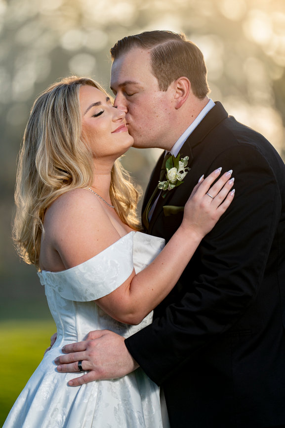 Bride and groom kissing during sunset