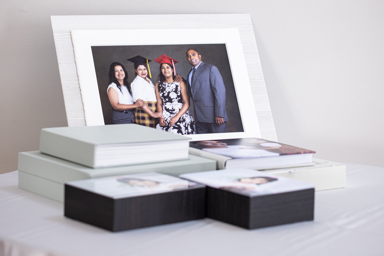 collection of portrait wall art albums and printed photographs displayed together in a refined presentation