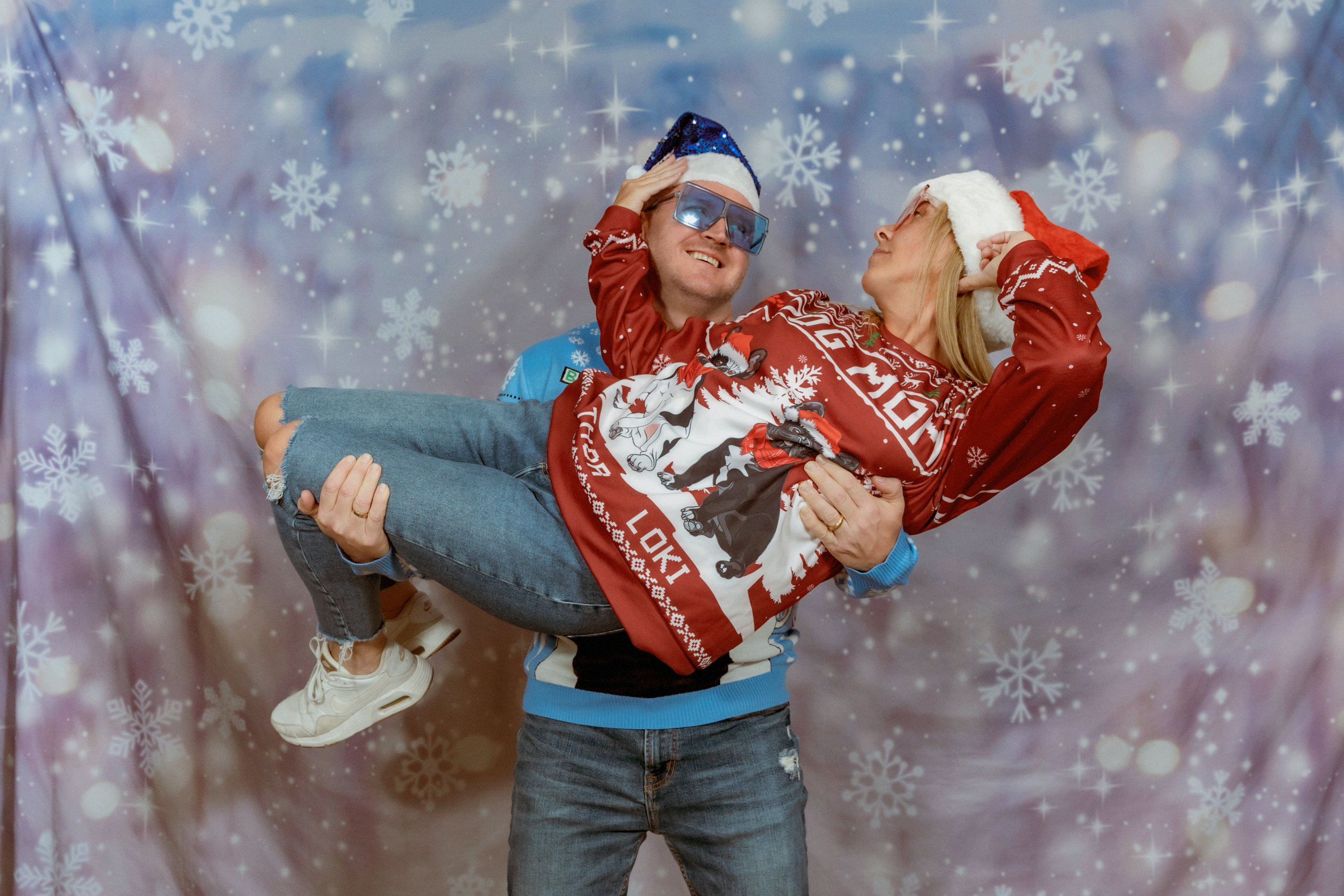 awkward family session of couple looking at each other longingly wearing ugly christmas sweaters