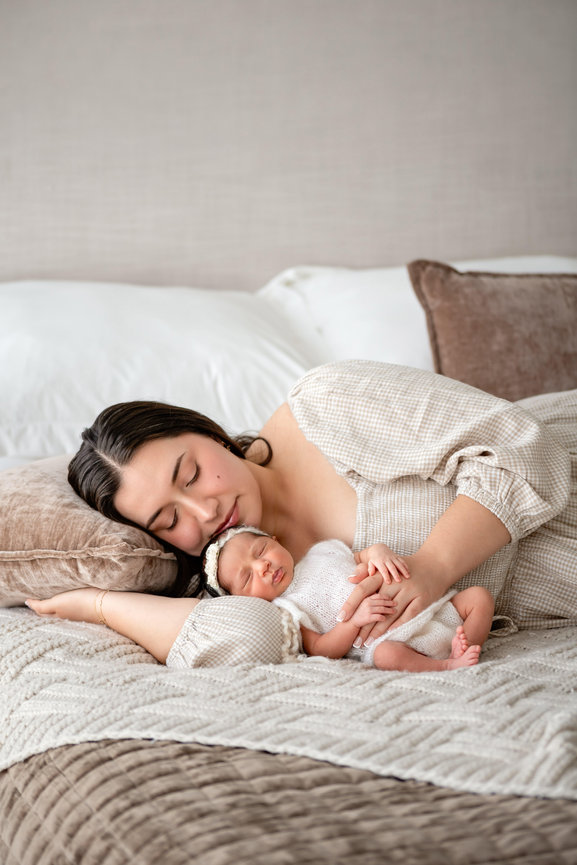 Mother sleeping with newborn baby on a bed in a cozy bedroom- studio Hillcrest