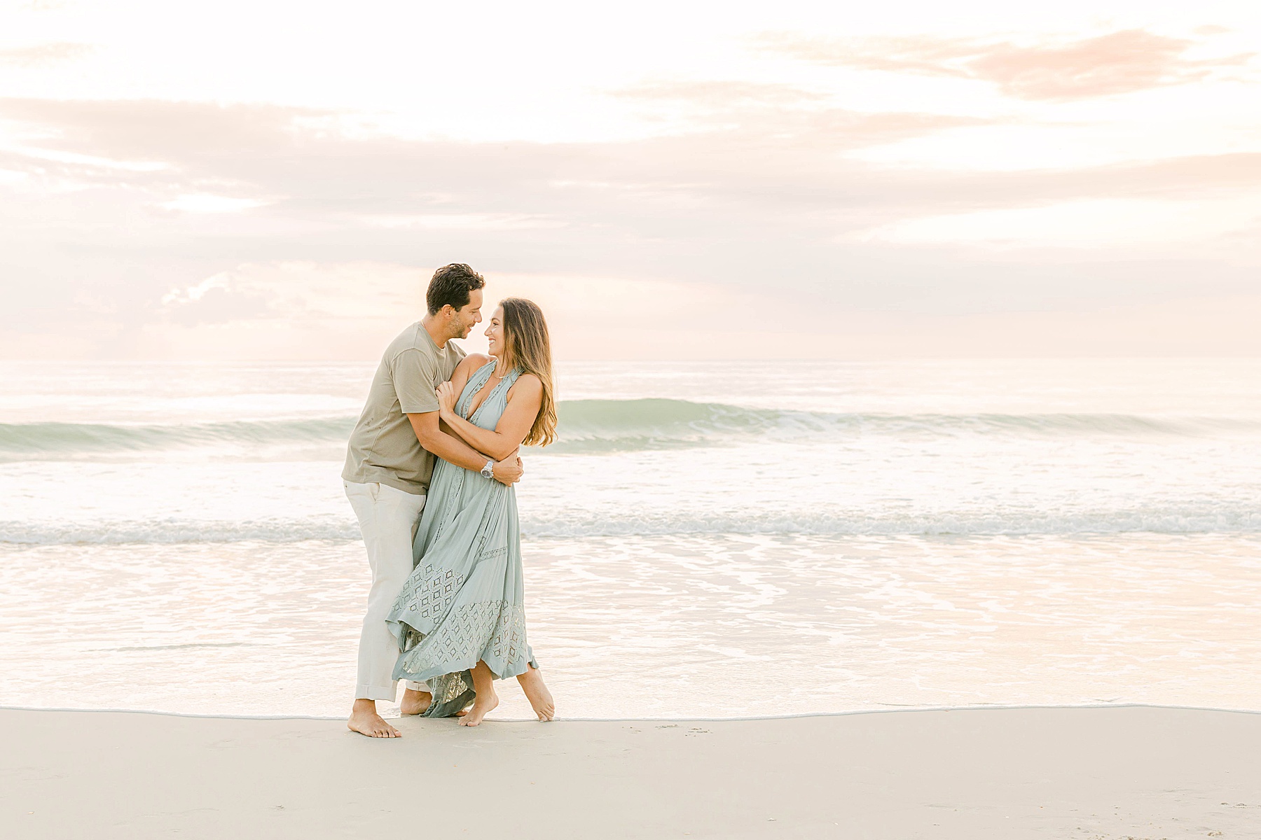 man and woman dancing on the beach