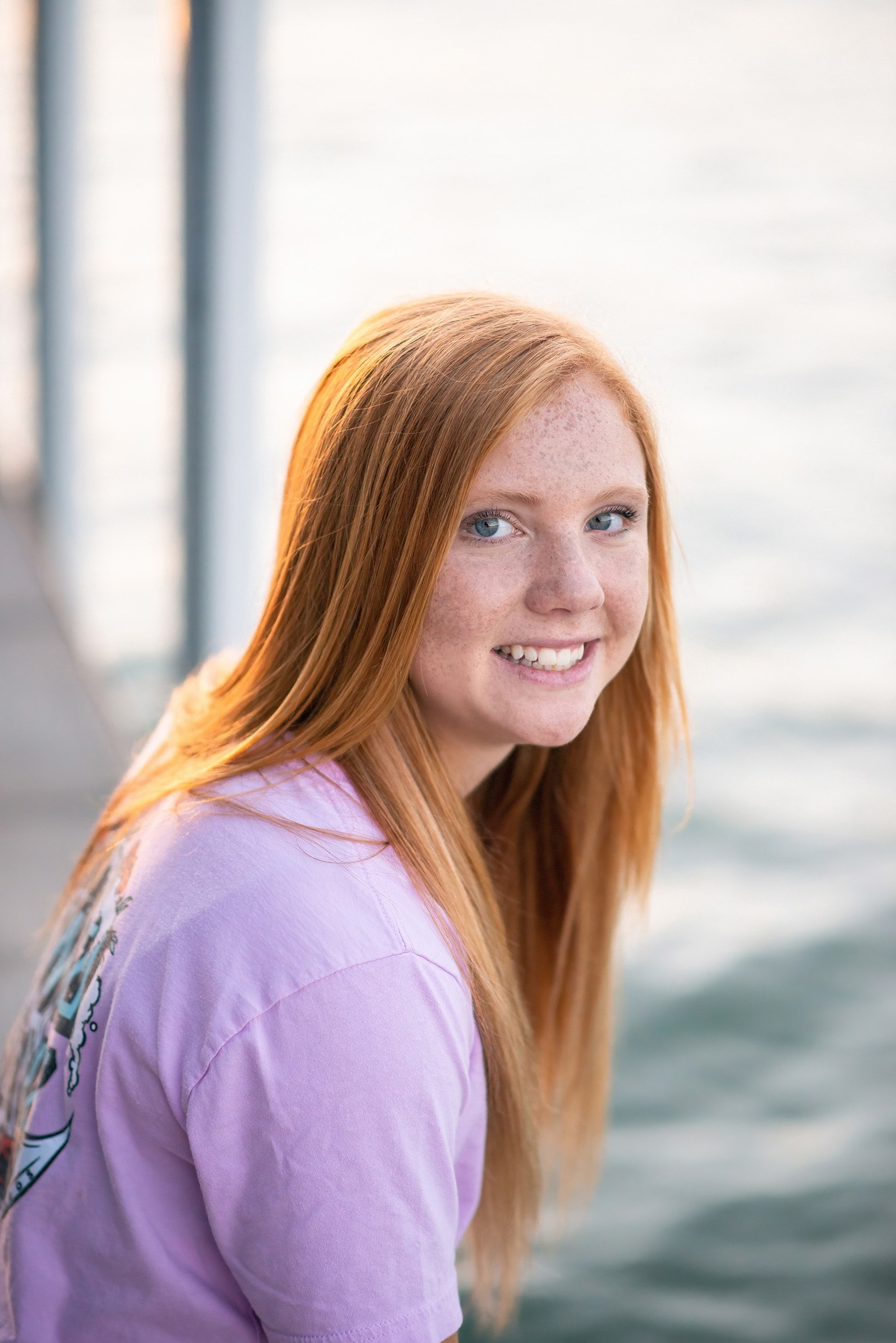 Senior girl in pink tshirt sitting on dock near Branson at Tablerock Lake.