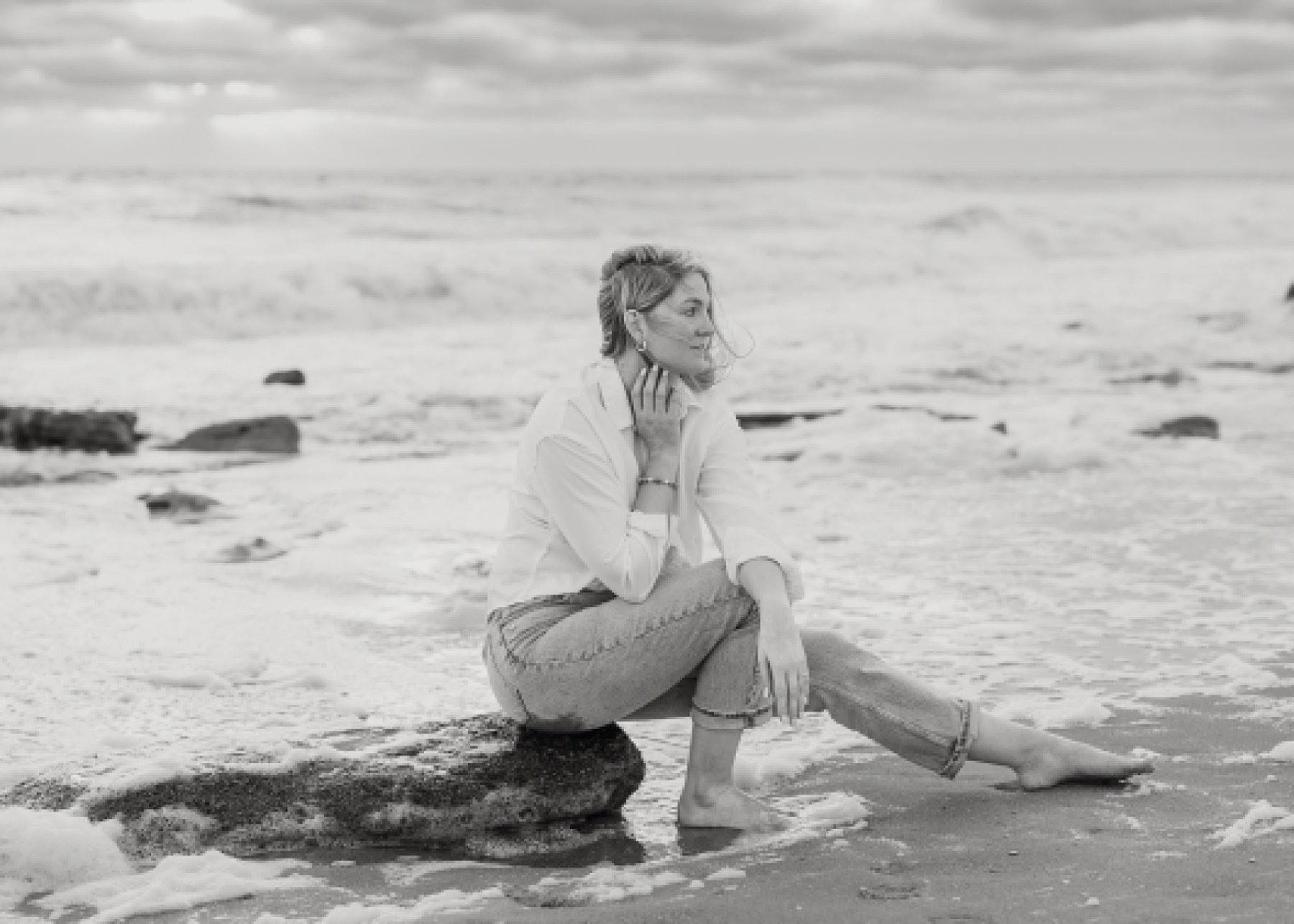 black and white portrait of woman in white shirt and jeans on the beach at sunrise in st. augustine florida