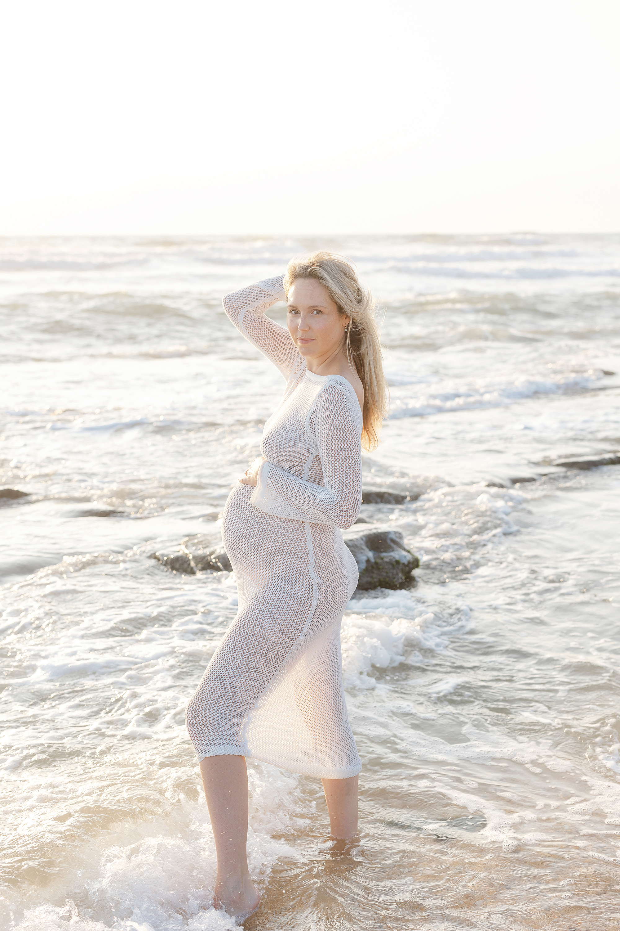 Sunrise maternity session in St. Augustine Beach with white fishnet dress.