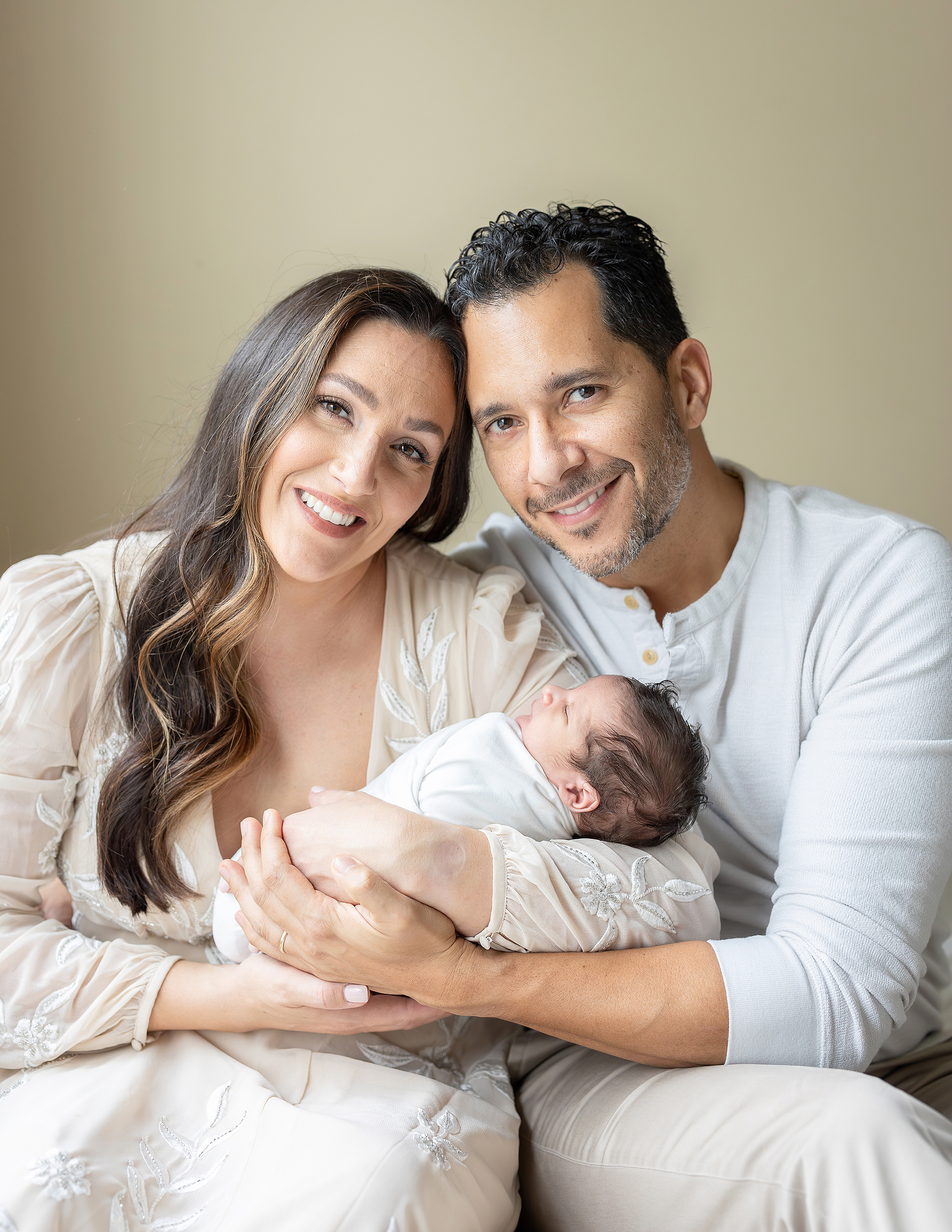 At home newborn portrait of man and woman with their newborn baby boy.