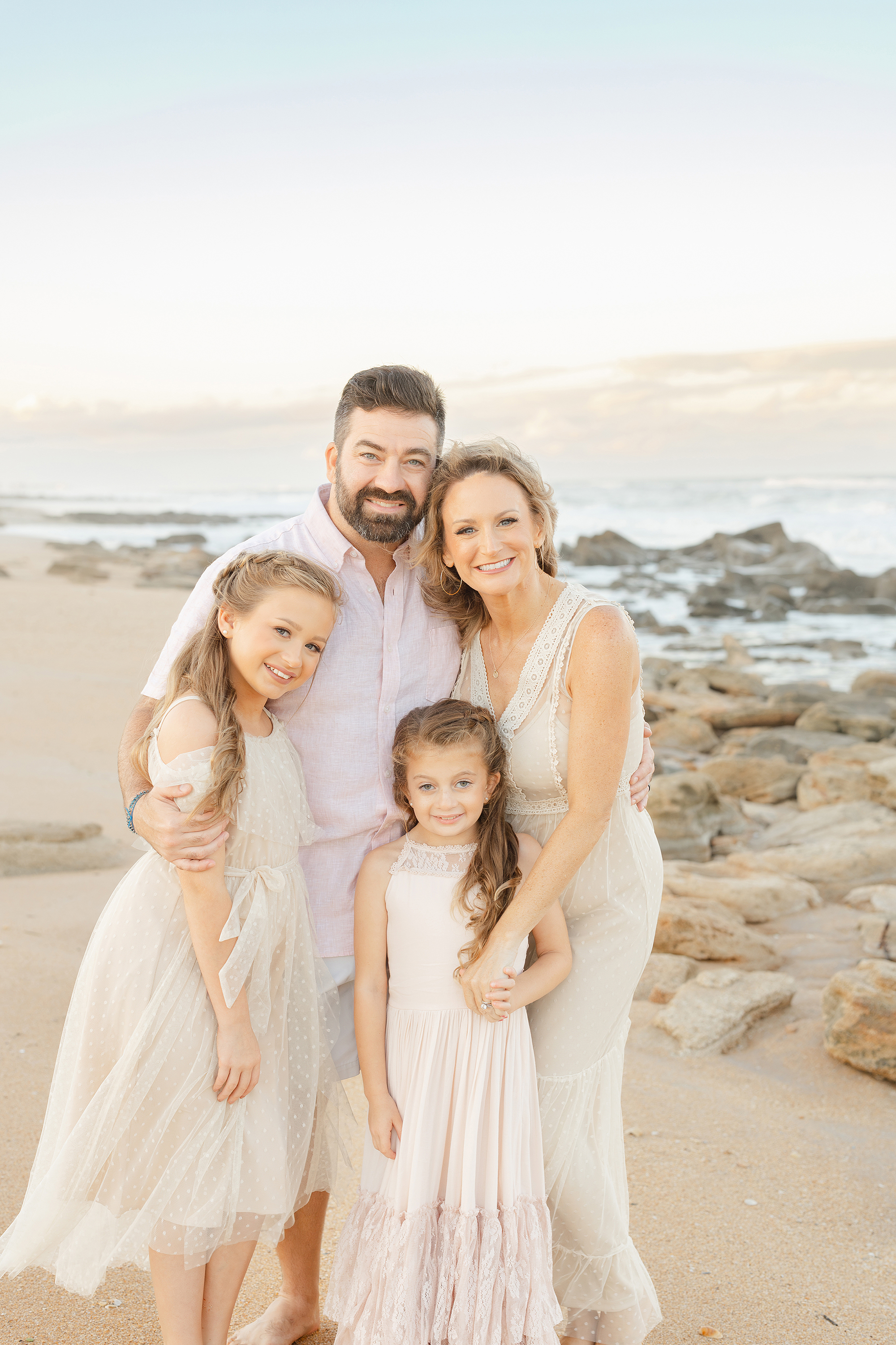 Colorful pastel sunset portrait of a family on St. Augustine Beach at sunset.