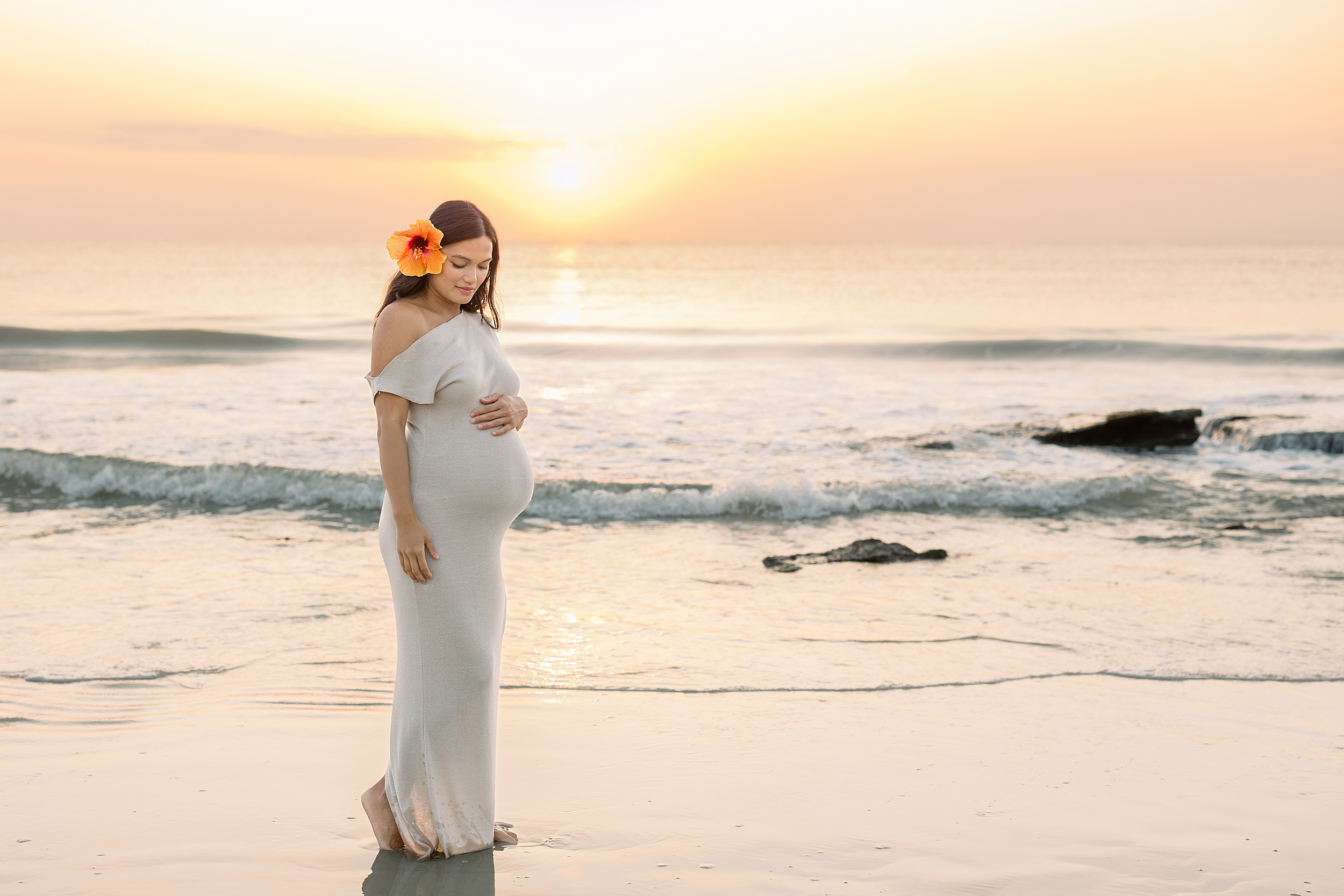 A sunrise maternity portrait of a woman on St. Augustine Beach.