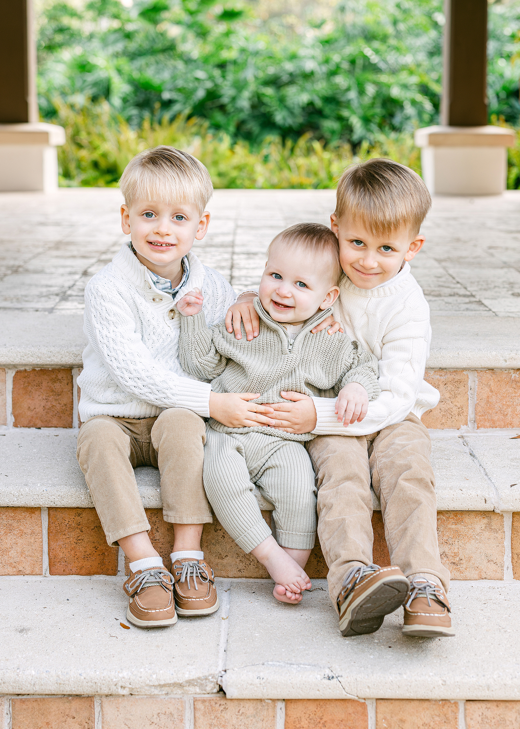 Three little boys sit on stone steps at the Cloister Sea Island, Georgia.