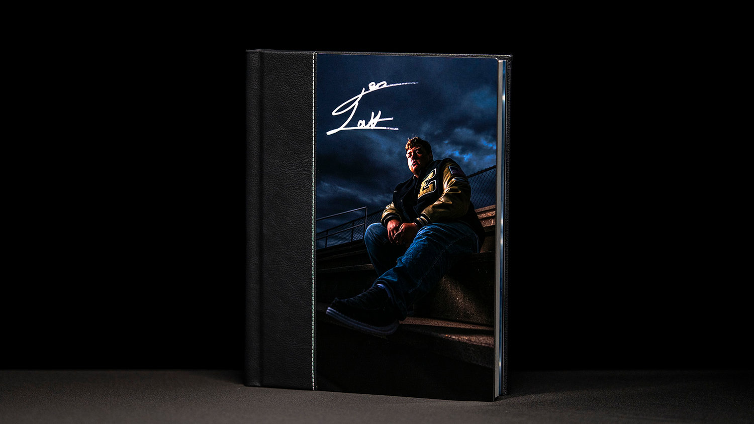 A hardcover book featuring a person sitting outdoors at dusk with a dramatic sky in the background.