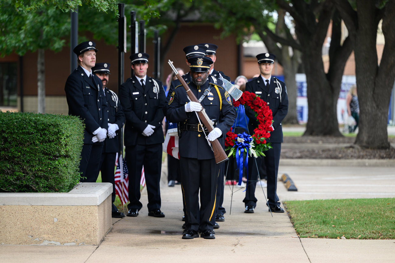 Police and Fireman honor guard standing at attention during a memorial ceremony outdoors