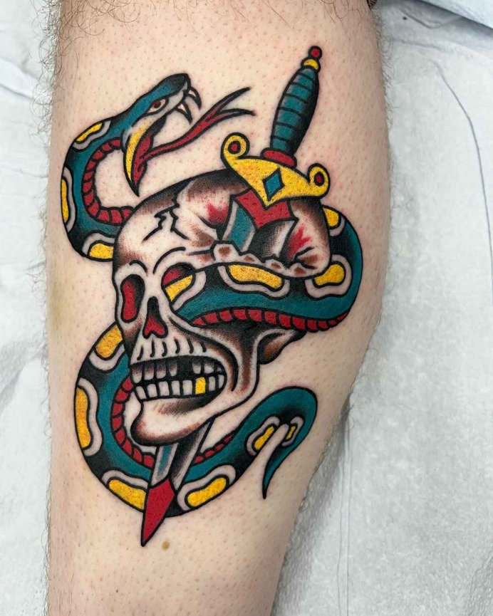 Traditional tattoo design of a snake, skull, and dagger with bold black outlines and green, red, and gold details made by Beam at Torch Tattoo.