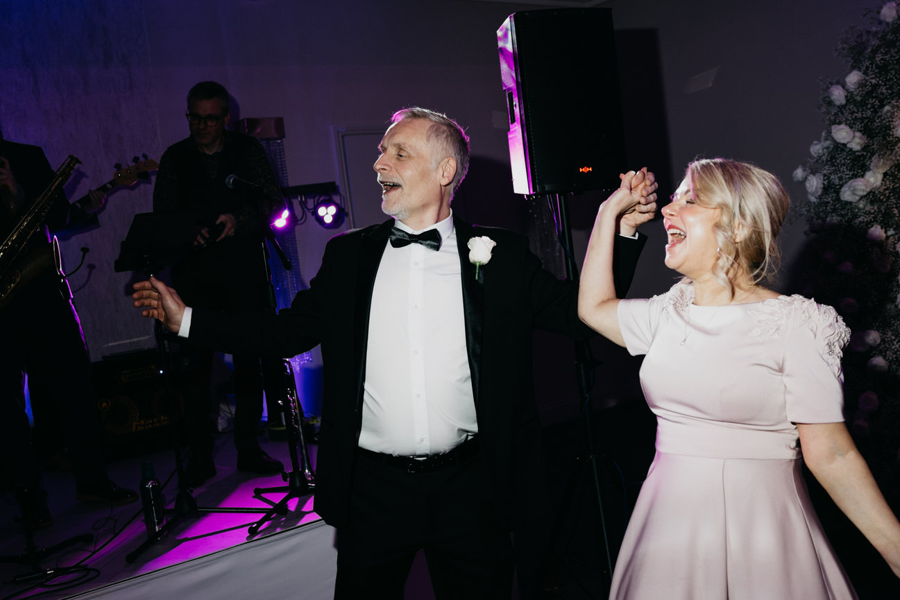 Editorial flash photography at Merrydale Manor; a candid, high-energy shot of the mother and father of the bride on the dance floor.