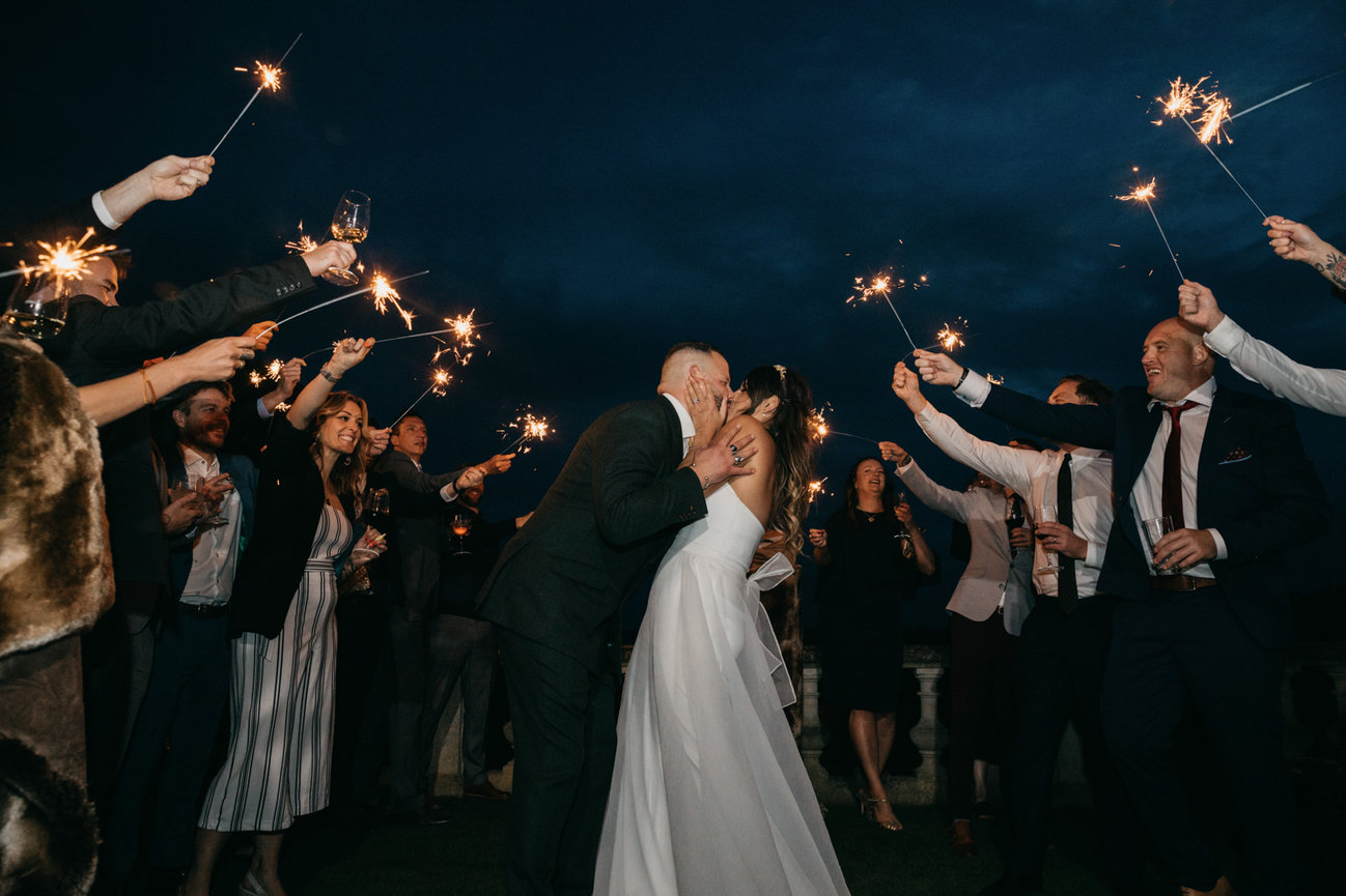 Relaxed wedding photography: Bride and groom kiss during sparkler exit at Euridge Manor.