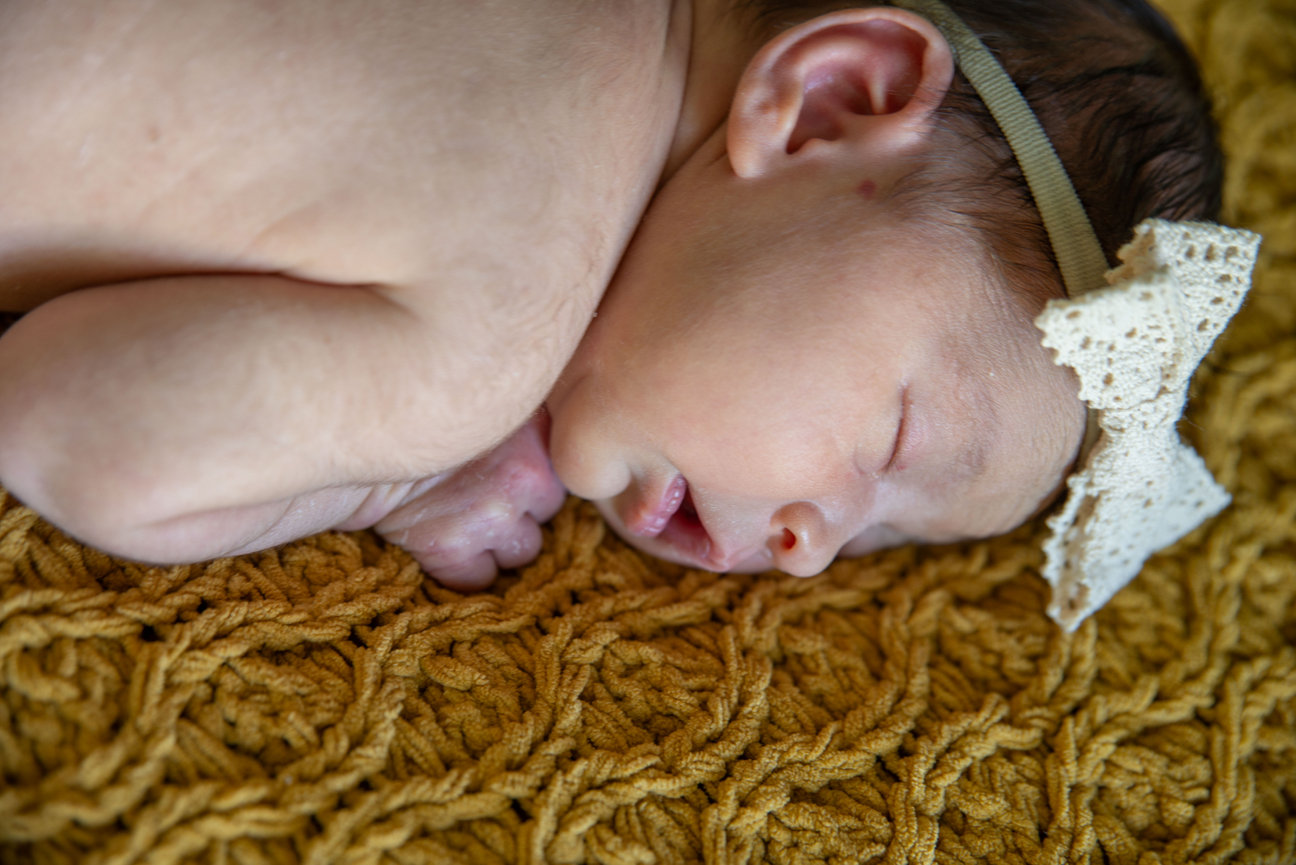 Close-up of a sleeping child resting on a patterned blanket.