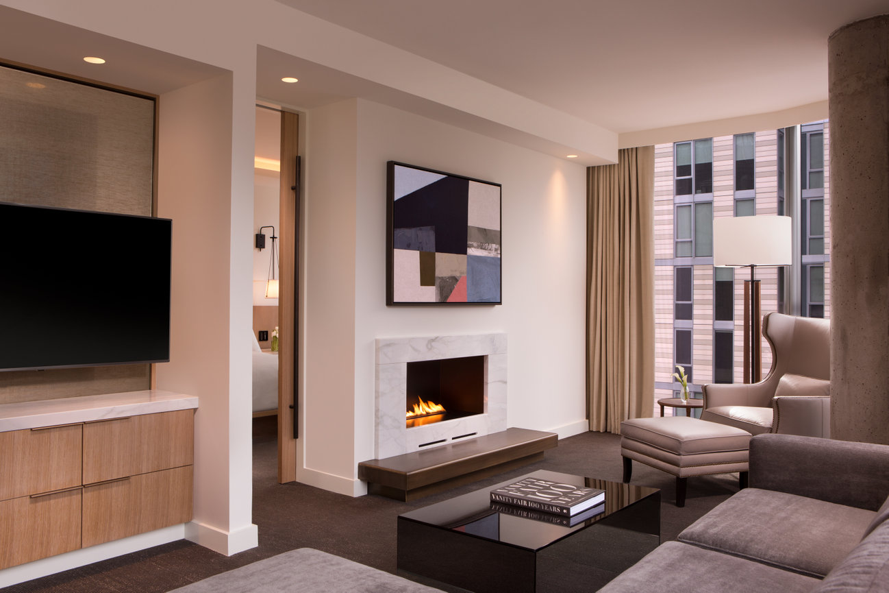 A Living Room in a Suite at the Conrad Hotel in DC with Fireplace beautiful artwork and modern furniture throughout.