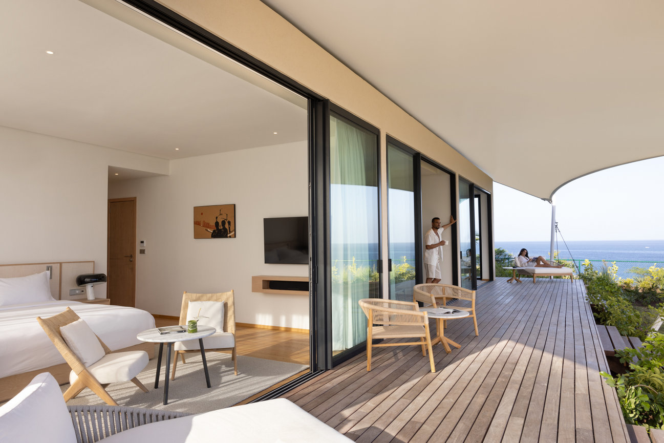 Large Guest room Suite looking from outside showcasing the beautiful all white interior and large deck on the ocean at Silversands Beach House in Grenada.