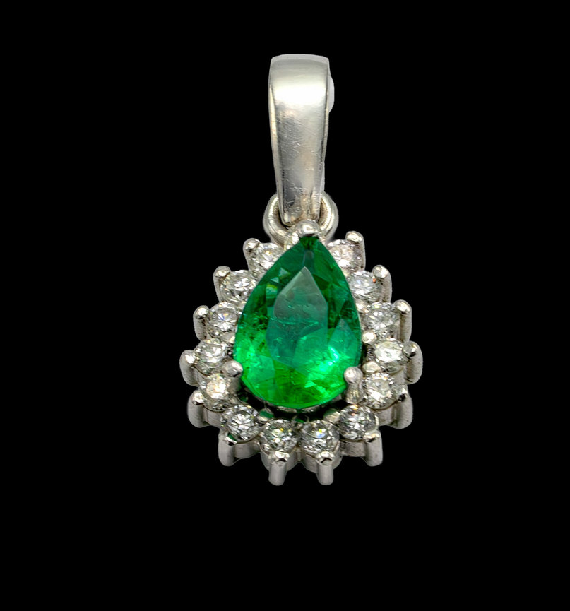 Platinum pendant with a pear-shaped green emerald surrounded by a halo of round diamonds, suspended from a polished bail, against a black background.