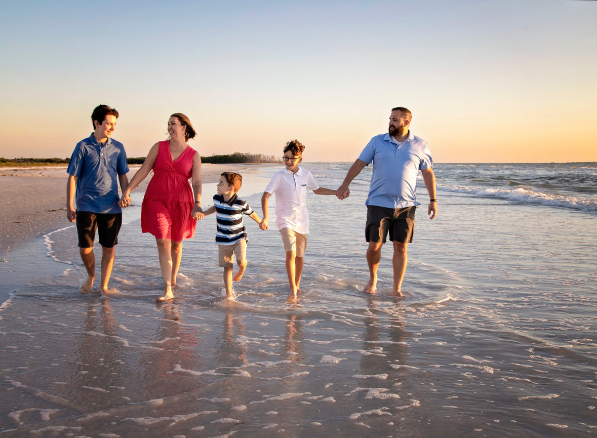 Family beach photoshoot walking along the water