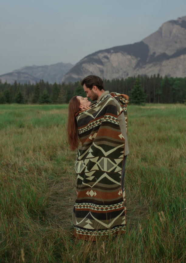 Couple wrapped in a blanket in a field
