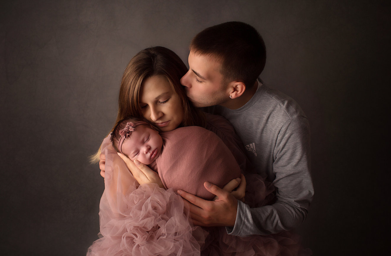 Newborn baby girl photographed with mom and dad with Kansas City newborn photographer Dreamworks Photography 