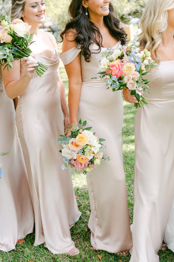 Blush bridesmaids holding colorful summer bouquets. Destination wedding photography by Heather Durham.