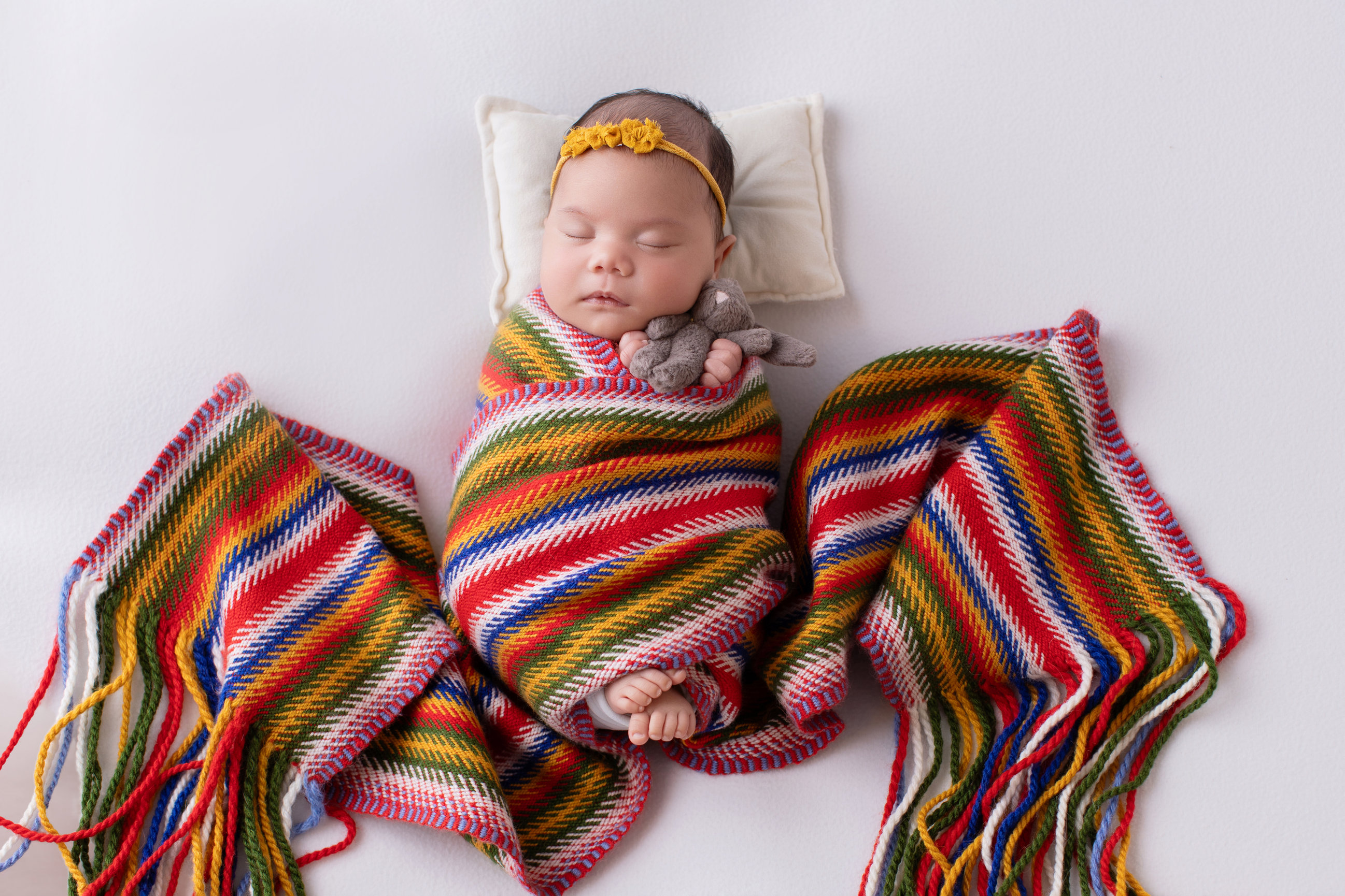 Newborn baby girl wrapped in a Métis sash, the finger-woven arrow-patterned sash of the Métis Nation