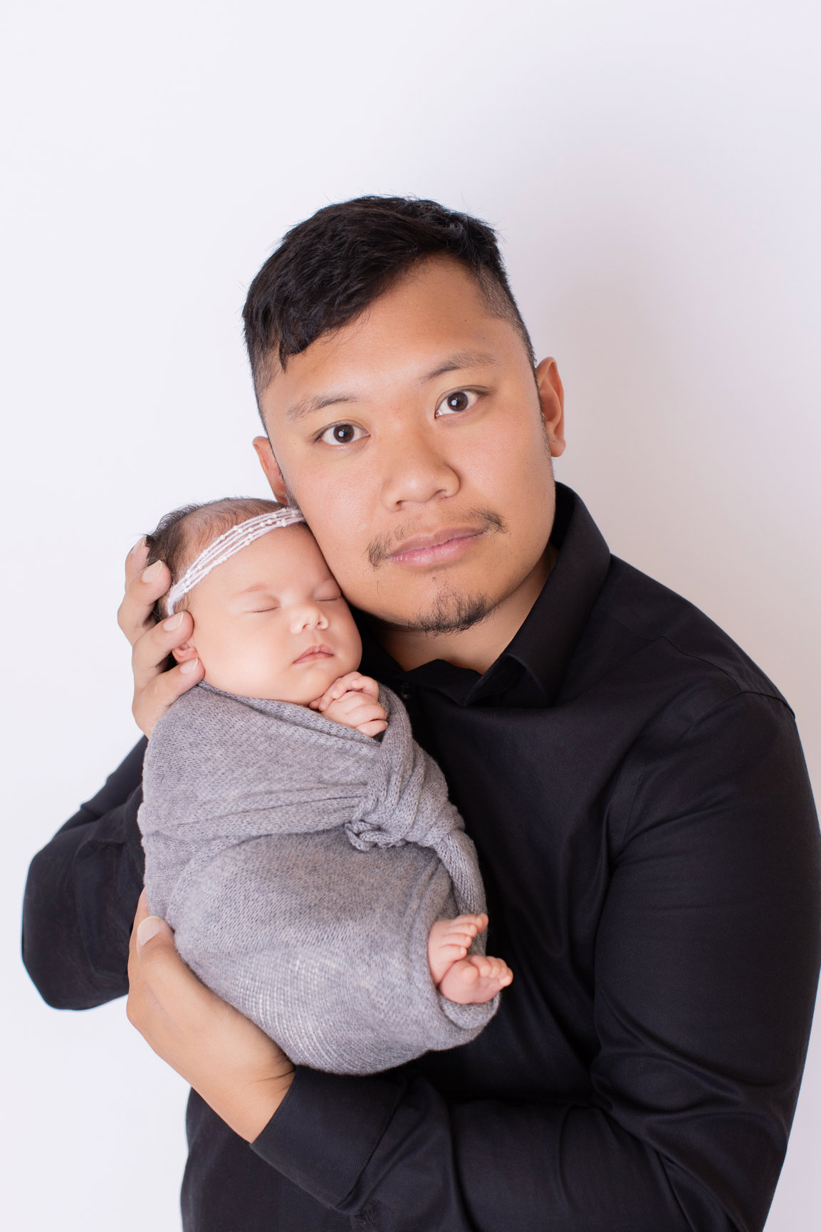Father holding his newborn daughter against his chest