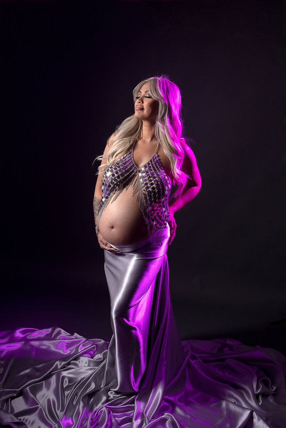 Pregnant mom in silver dress with purple light on her