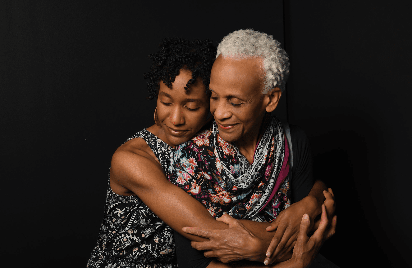 A female doctor and her daughter share a warm embrace during their family photo session at Kliks Photography.