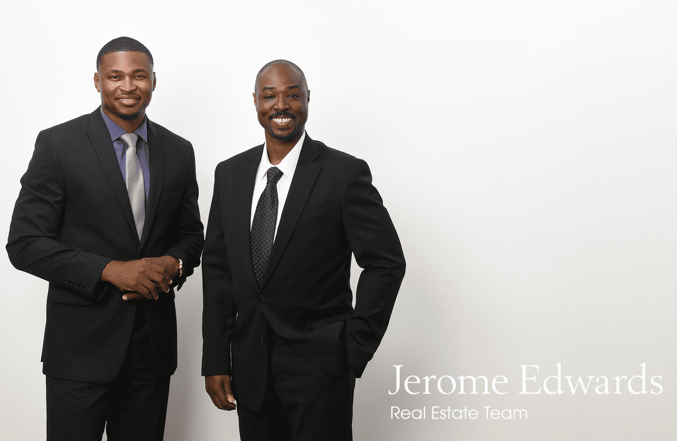 Two smiling and sharply dressed realtor men in suits.