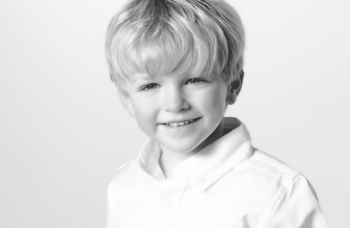 A young boy with tussled blond hair and crisp white shirt at Kliks Photography in Cedar Rapids, Iowa.