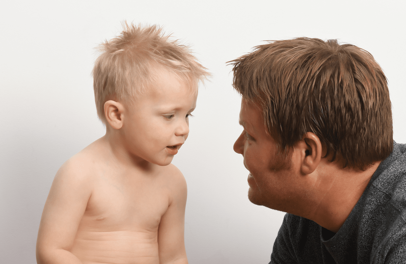 A toddler boy gets coached by his dad during his solo kid's photo session at Kliks Photography.