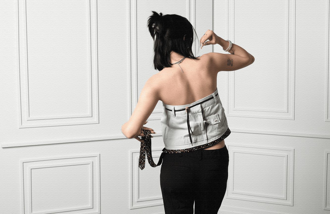 A female model strikes a pose wearing a fashionable top.