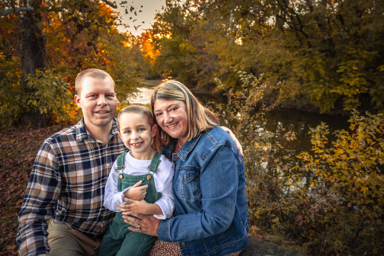Family sitting by a river in autumn
