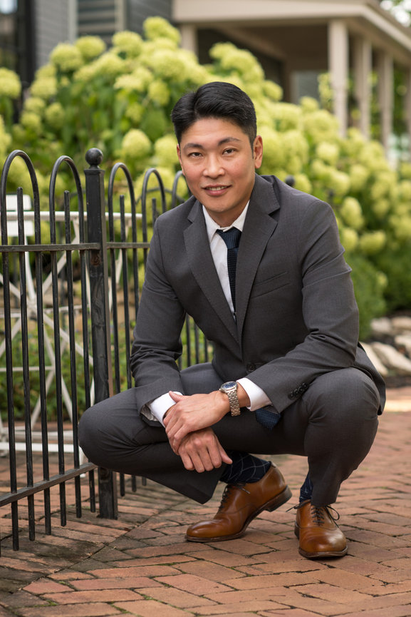 Professional headshot of male executive in a gray suit on a brick walkway, captured by Dublin Ohio headshot photographer Claudine Kosier for modern branding portraits